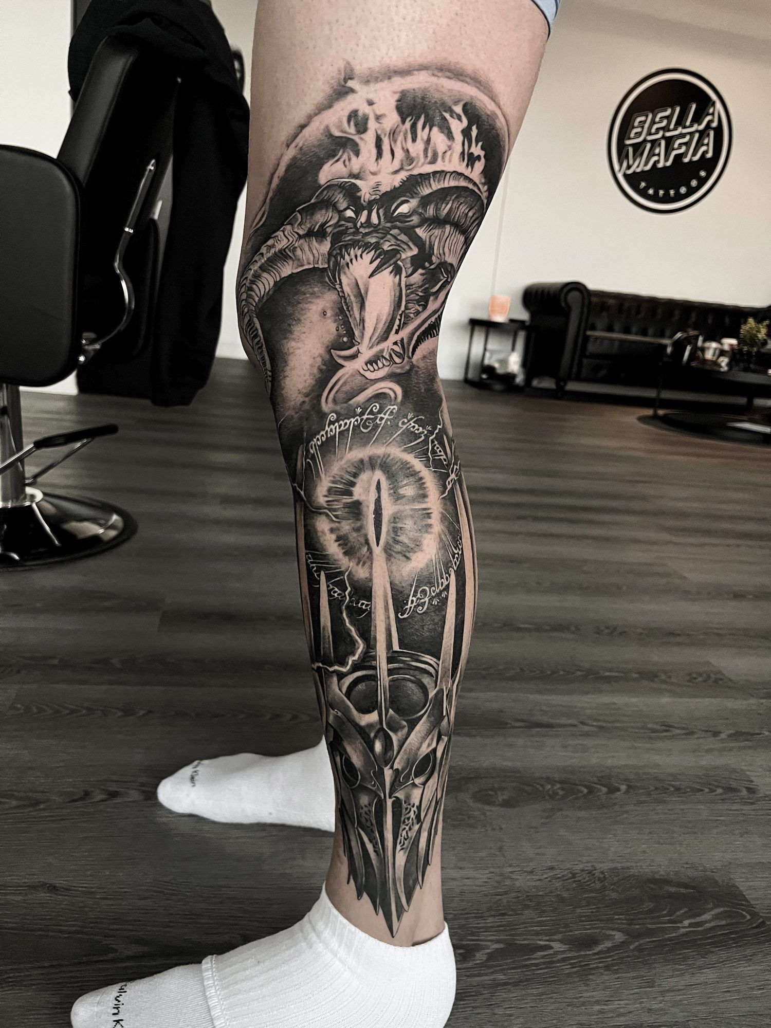 Black and grey leg sleeve with a horned fire demon, a glowing eye and a dark helmet.