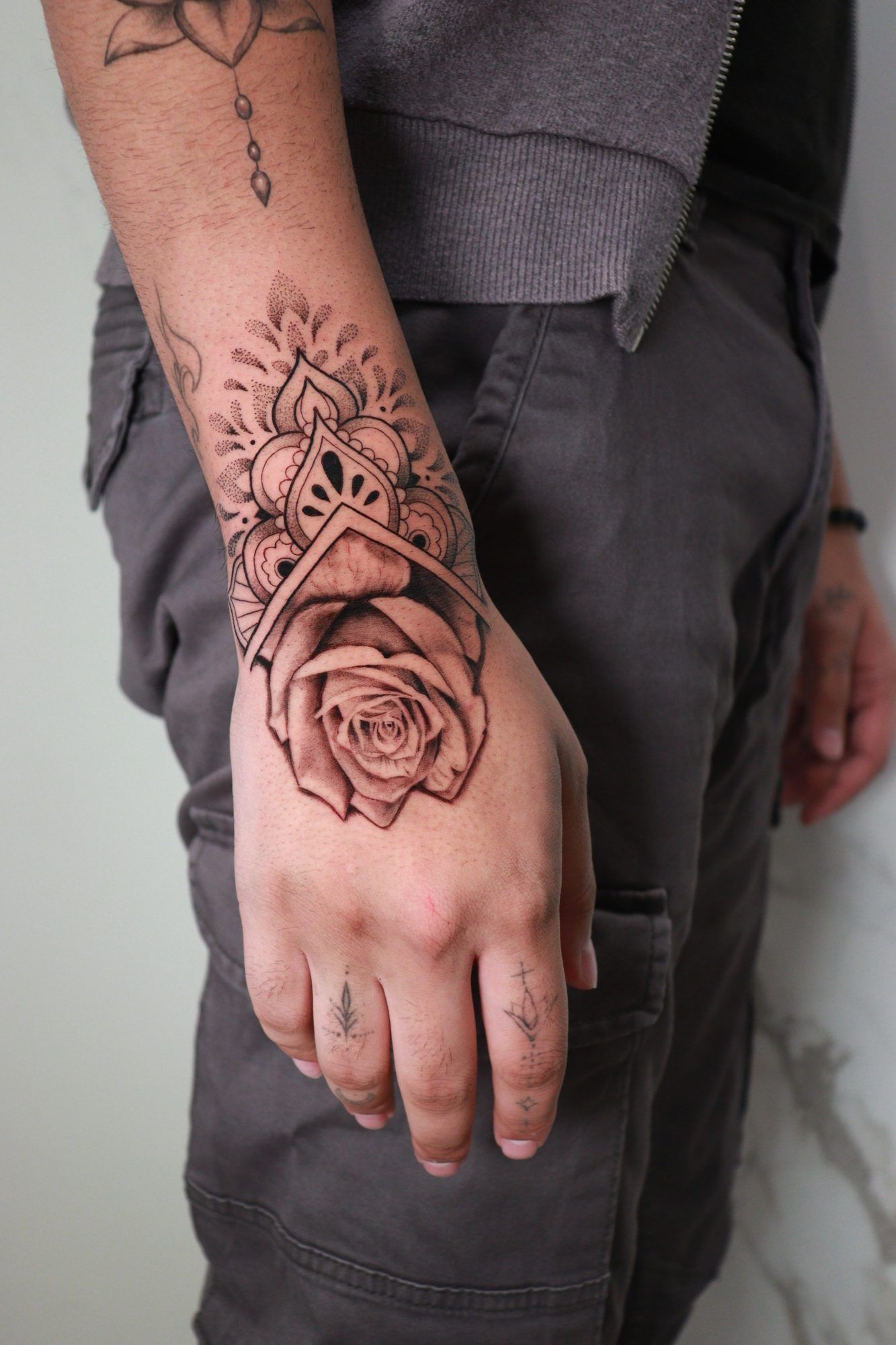 Rose with an ornamental mandala on the wrist and back of a hand.